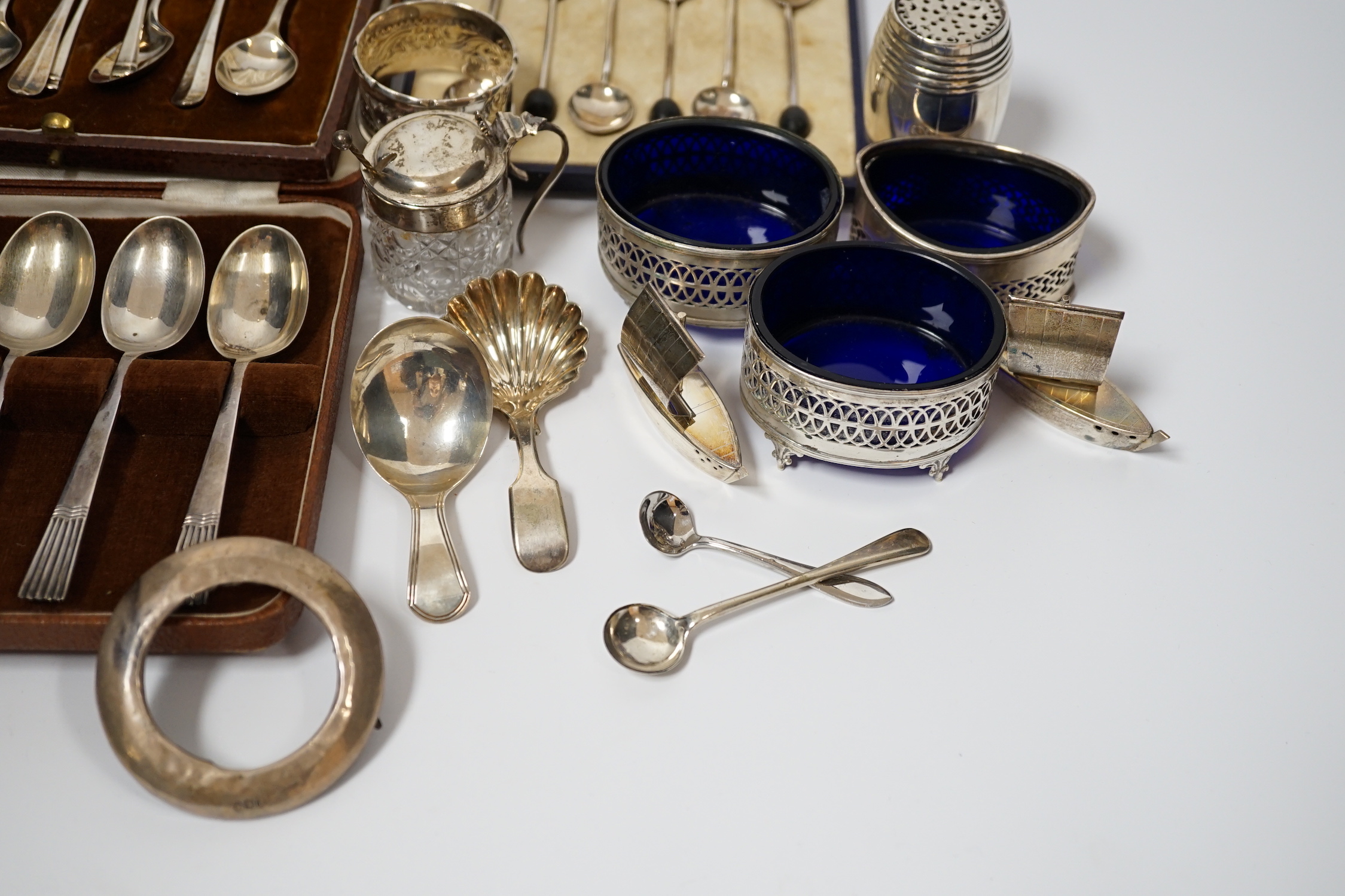 A white metal pepperette modelled as barrel and other silver and plated items including a Georgian caddy spoon, condiments, three cased sets of silver spoons, etc.